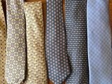 six different colored ties are lined up on a wooden surface
