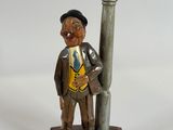 a figurine of a man smoking a cigarette next to a lamp post