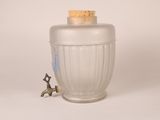 a small figurine that is next to a glass jar