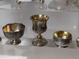 a glass display case with silver objects on it