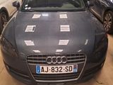 a car that is parked in a garage with other cars in the background