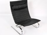 fauteuil en cuir noir avec des pieds chromés sur fond blanc