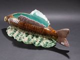 a ceramic fish shaped bowl with a fish tail on it