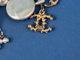 a close up of a broocher with pearls and charms