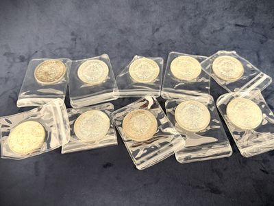 six gold coins in clear plastic bags sitting on a black surface