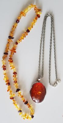 a necklace with a red glass bead and a silver chain