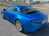 une photo d'une voiture de sport bleue garée sur le bord de la route