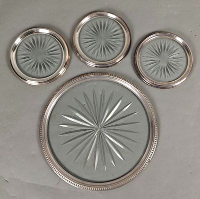 quatre morceaux de verre aux bords argentés posés sur une surface grise