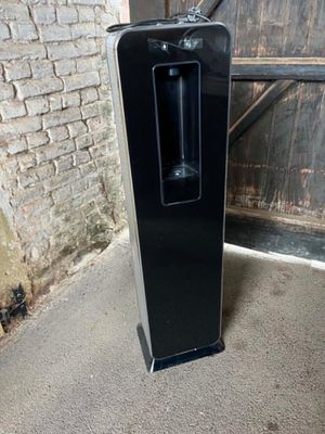 a black refrigerator sitting in front of a brick wall