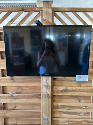 un téléviseur posé sur une palette en bois, avec une personne en train de prendre une photo
