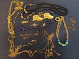 many different necklaces and bracelets laid out on a table