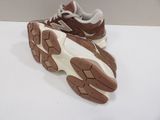 pair of brown and white running shoes on a white surface