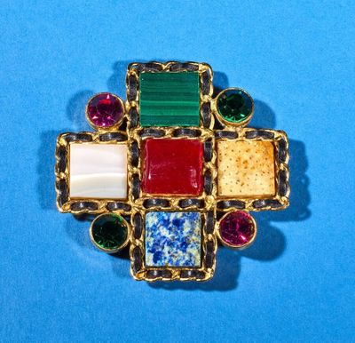 a close up of a colorful broochle on a blue surface