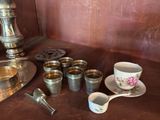 cups and spoons sitting on a table next to a teapot