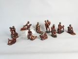 several figurines of people sitting on a white surface