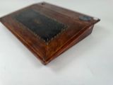 a small wooden box with a black and gold design on it