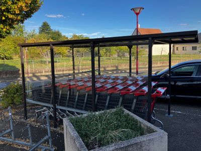 cars parked in a parking lot next to a shopping cart