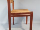 a wooden chair with a woven seat on a white background