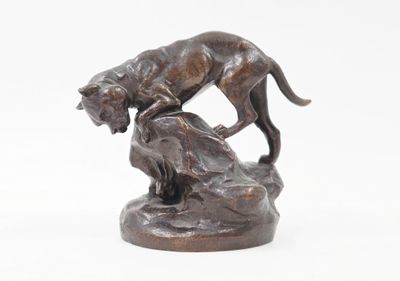 statue représentant un chien et un chat posés sur un rocher, sur fond blanc