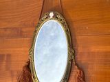 un miroir accroché au mur, entouré d'un pompon