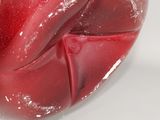 a red apple that is sitting on a white surface