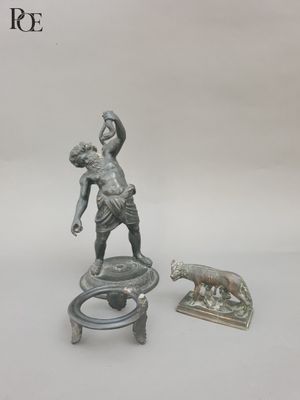 a statue of a man holding a baby on a stool
