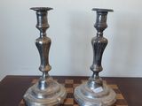 deux bougies argentées posées sur un échiquier posé sur la table