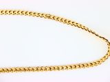 a close up of a gold chain on a white surface