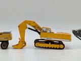 four toy construction vehicles that are lined up on a white surface