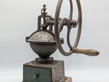 an old coffee grinder sitting on top of a wooden base