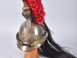a helmet with a red feather on top of it