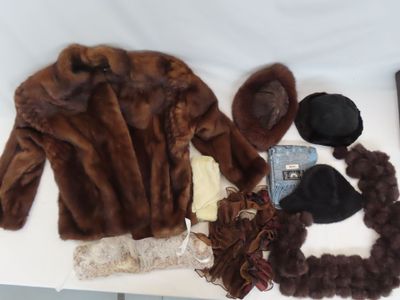 un manteau de fourrure, un chapeau, des gants et d'autres objets posés sur une table