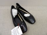 a pair of black shoes with a white bow on them