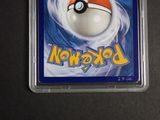 a pokemon card in a plastic case on a table