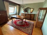 une pièce dans laquelle se trouvent une table, une commode, un miroir et un lustre