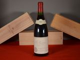a bottle of wine sitting on a table next to two wooden boxes