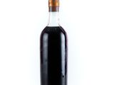 a bottle of syrup sitting on a white surface