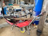 une brouette rouge dans un garage rempli d'outils