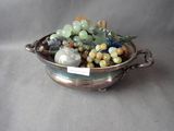 a silver bowl filled with assorted beads and stones