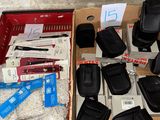 une boîte remplie de téléphones portables et d'autres objets, posée par terre