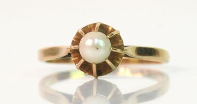 une image représentant une bague en or avec une perle au centre