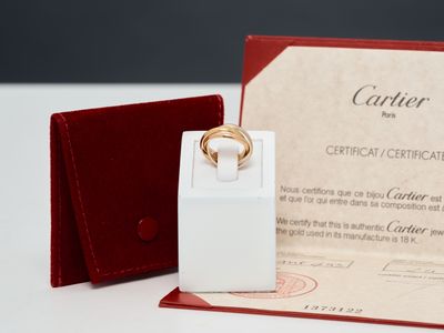 une bague posée sur une boîte, à côté d'un certificat