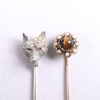 two pins with a cat ' s head and a tiger ' s head on them
