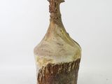 a brown and white vase with a bird on top of it