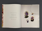 an open book with a picture of jewelry and flowers on it