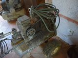 a small air compressor sitting on a cart in a room