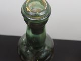 deux vases en verre vert posés sur une table noire
