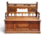 un banc en bois dont le dossier est orné de sculptures