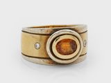 Gros plan sur une bague contenant une pierre orange