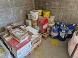 une pile de cartons et de pots de peinture dans un coin de la pièce